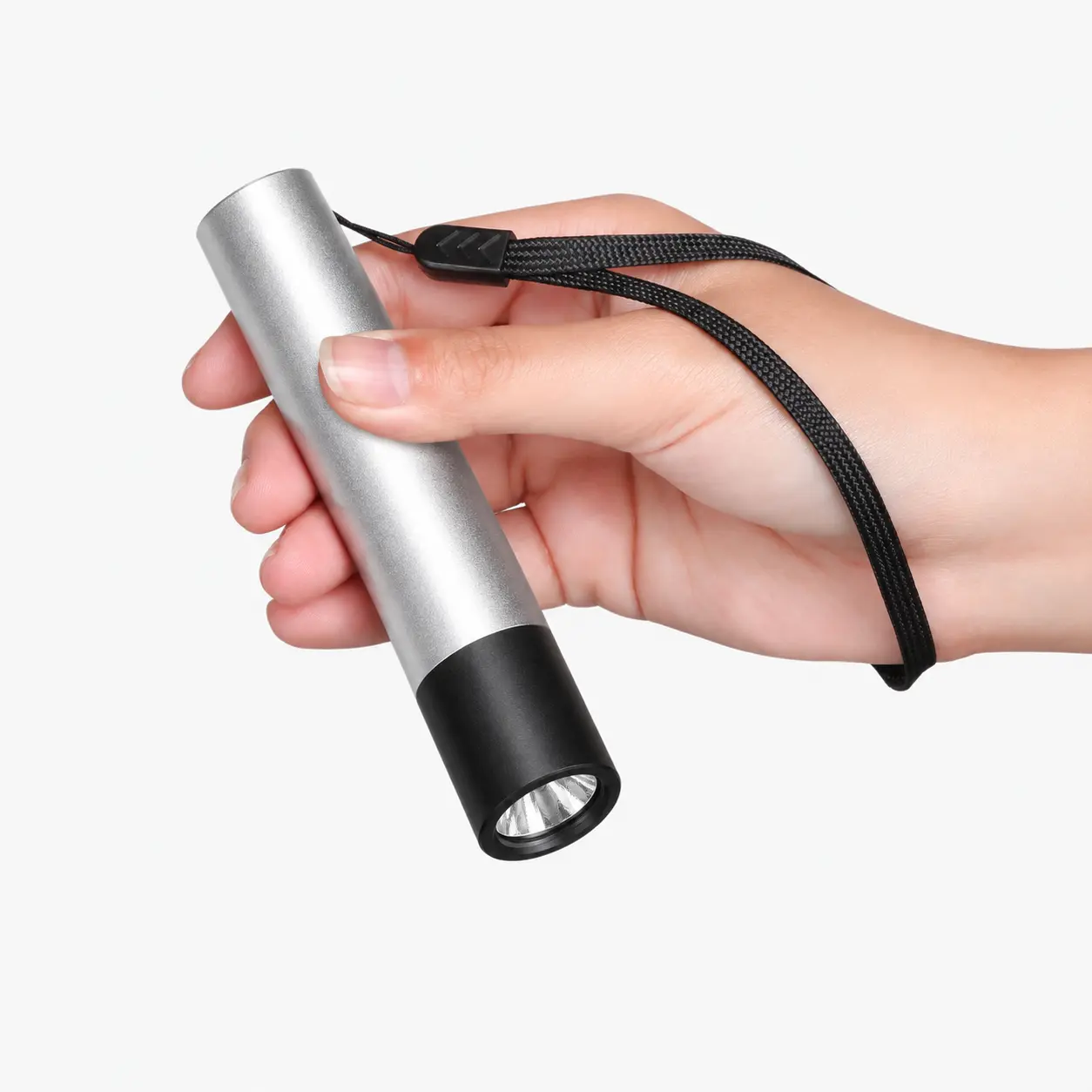 Compact and ergonomic Buudy LED Torch held in hand with safety wrist strap demonstrating portable travel-ready size