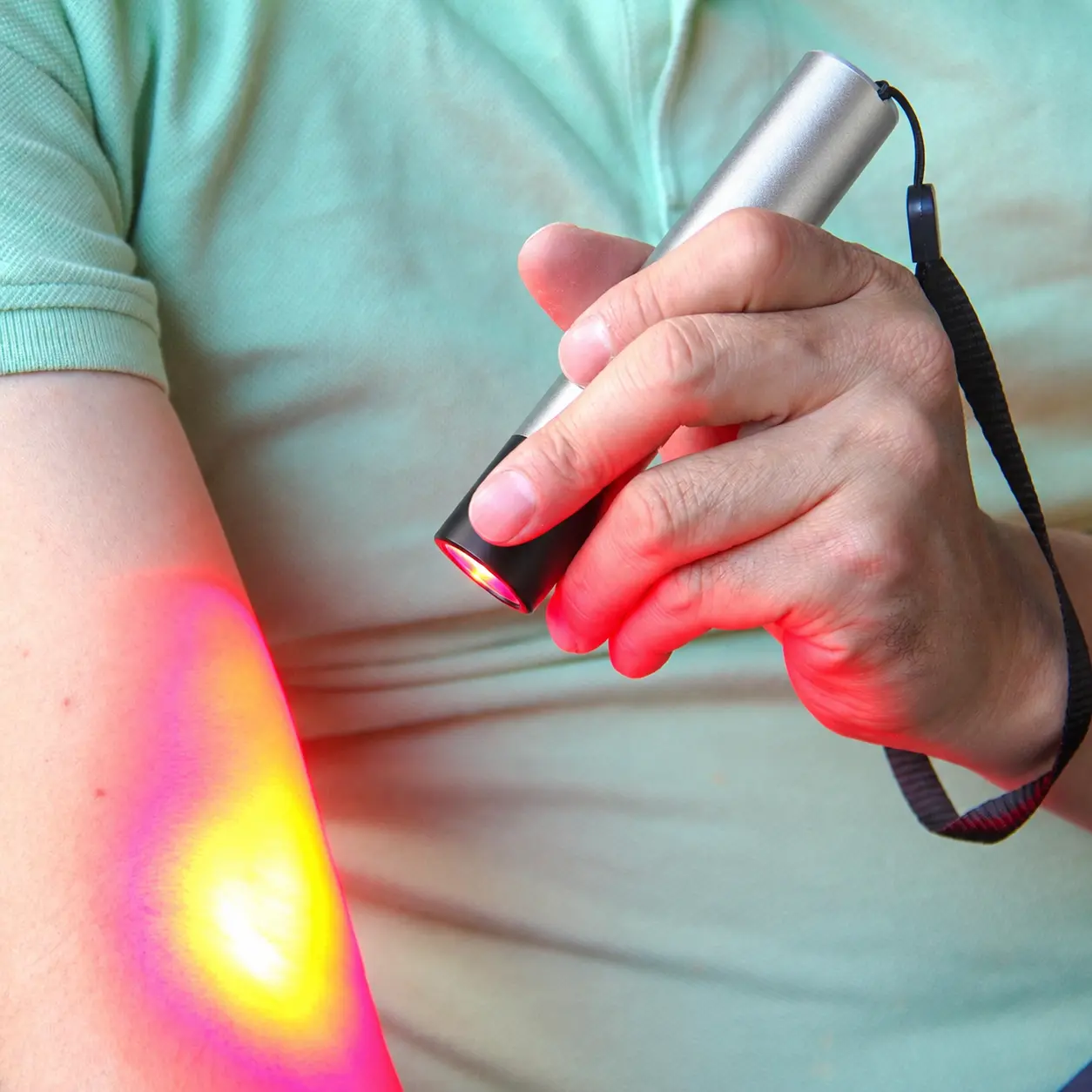 Close-up of Buudy LED Torch emitting concentrated 630nm, 660nm, and 850nm wavelengths for deep tissue muscle recovery and elbow joint relief